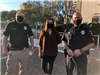 Two police officers pose for a photo with a woman at the City Hall courtyard.