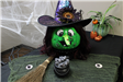 Pumpkin witch with cauldron of candy and broomstick