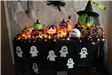 Pumpkins decorated as witch, goblin, skeleton, mummy, vampire, Frankenstein on table with cobwebs
