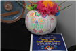 Pumpkin decorated as sugar skull with flyer for Dia de los Muertos event
