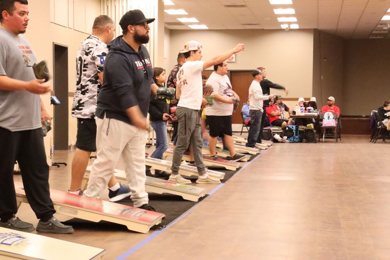 Row of people playing cornhole at the Victoria Community Center annex