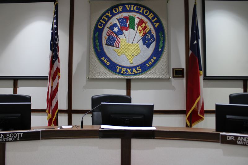 The mayor's chair sits empty at the City Council dais.