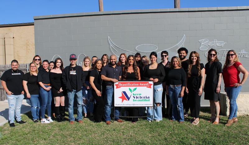 Group photo in front of decorative angel wings and the words Better Together