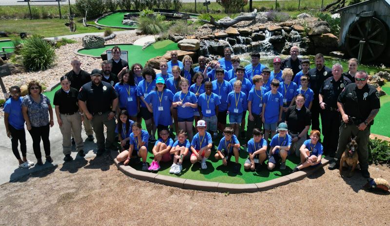 Group photo of police officers and children at Outlaw Pass