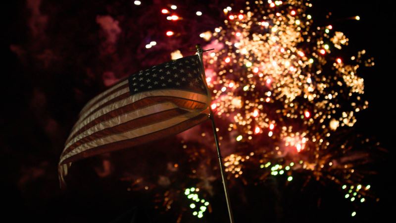 Fireworks with a small American flag in the foreground
