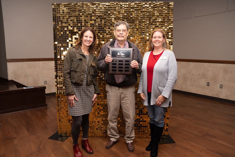 Man holding an inscribed plaque