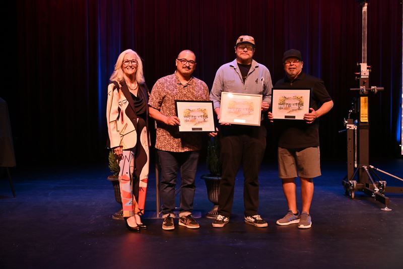 Group photo of four people, three holding plaques featuring the De Leon Plaza gazebo