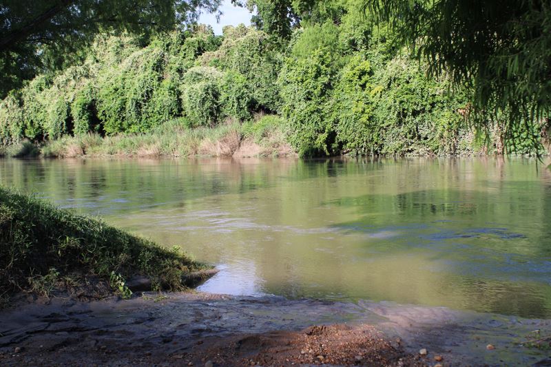 River flowing high near Riverside Park boat ramp with mud at the edge of the ramp