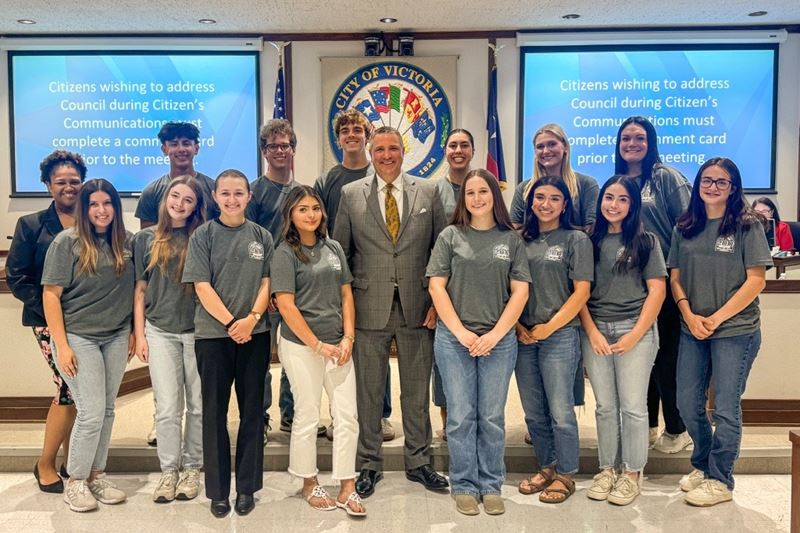 Group photo with Mayor, a large group of high schoolers and a young woman at Council chambers