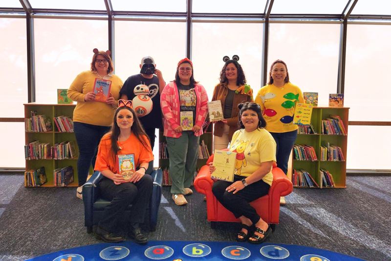 Library staff dressed as characters including Arthur, Garfield, Pooh, Junie B. Jones and Darth Vader