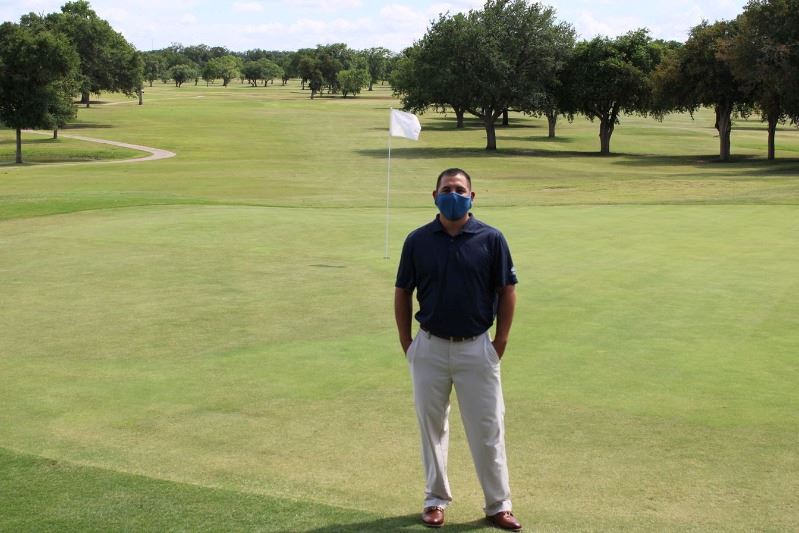 Man stands on golf course wearing facial covering