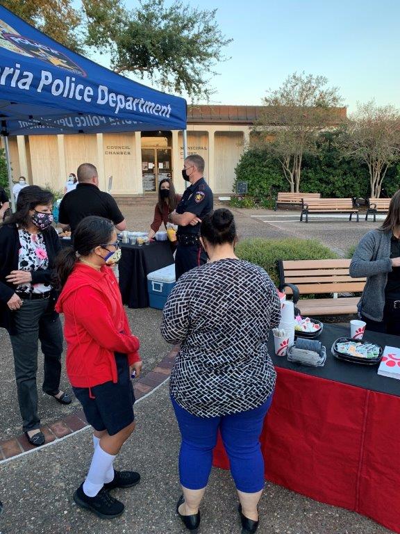 Residents and City staff get breakfast from a Chik-fil-A table in the City Hall courtyard