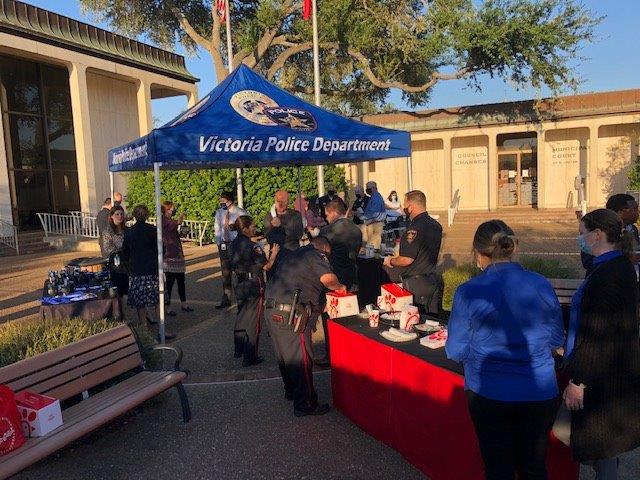 Police and residents mingle near a Victoria Police Department booth in the City Hall courtyard.