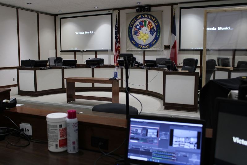 A Zoom video feed is displayed on projector screens behind the Municipal Court dais.