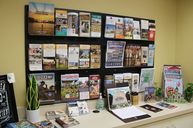 A brochure rack sitting on a cabinet countertop is filled with brochures and magazines.