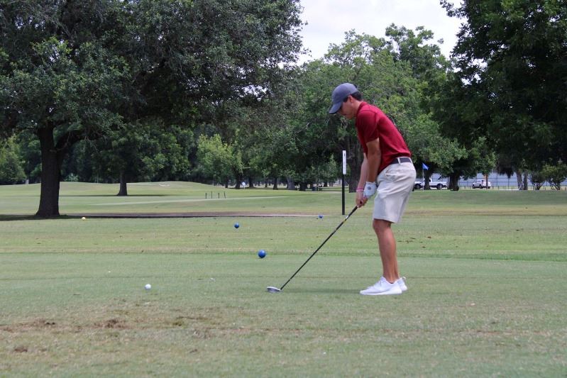 Man preparing to hit tee shot on golf course.