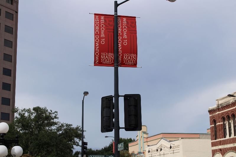 A maroon banner with white lettering at DeLeon Plaza reads, 
