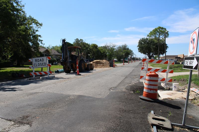Road barricades, an excavator, traffic cones and other signs of road work on Crestwood Drive
