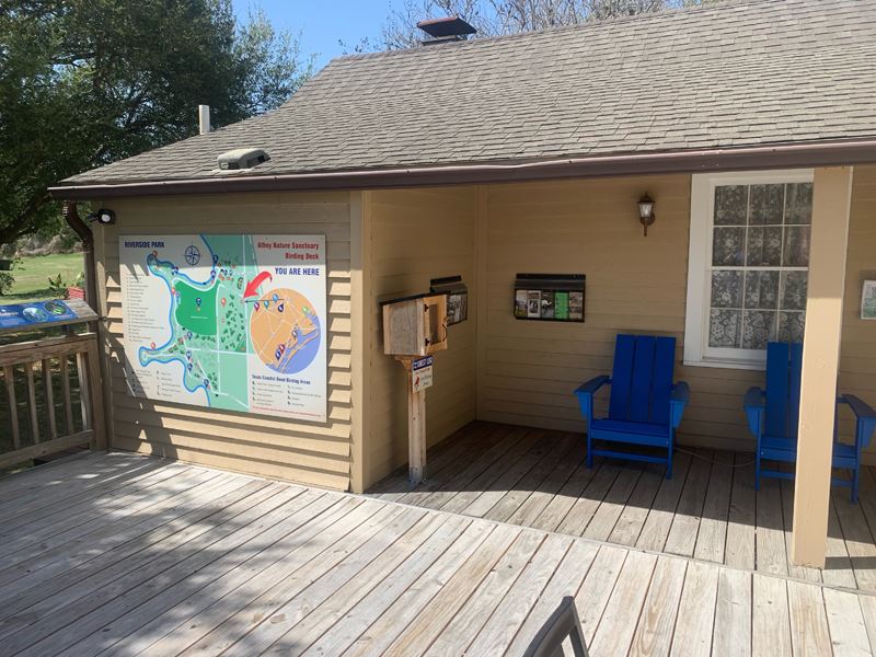 Beige house with bright blue chairs and a large map on the wall