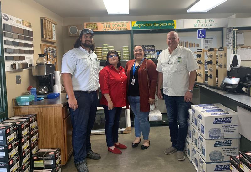 Four people pose for a photo in a work area at McCoy's Building Supply.