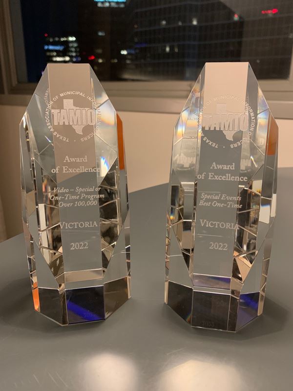 Two glass trophies that say Award of Excellence.