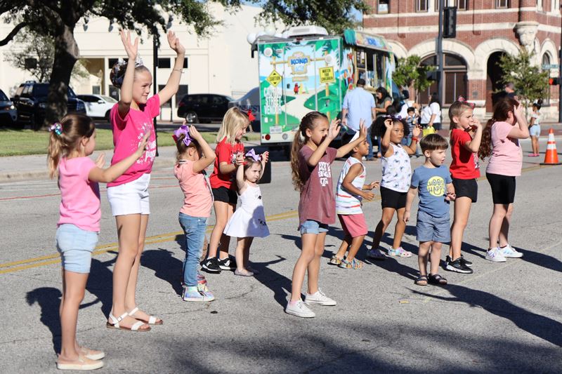 Kids dancing in a line near DeLeon Plaza
